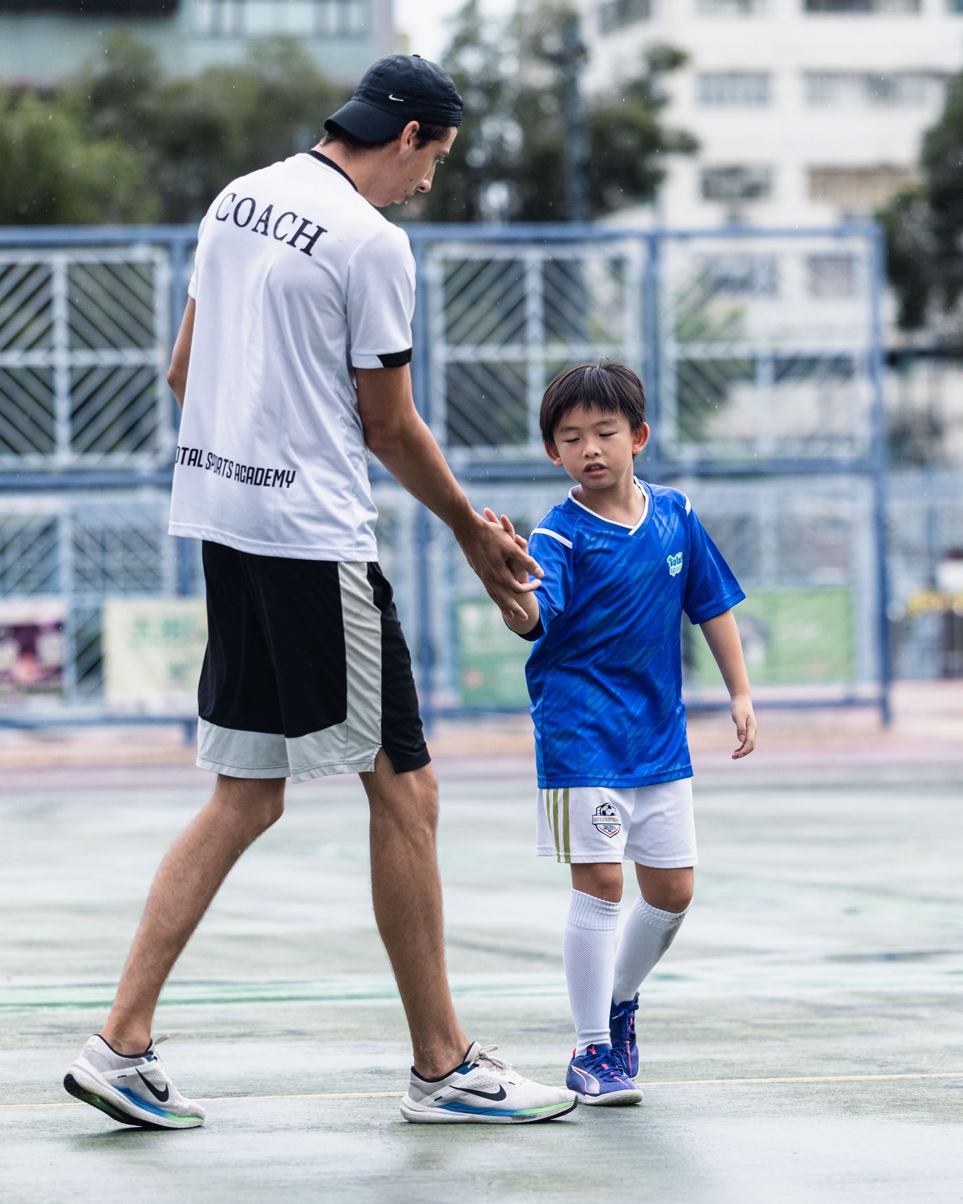 Coach walking a young student to the pitch