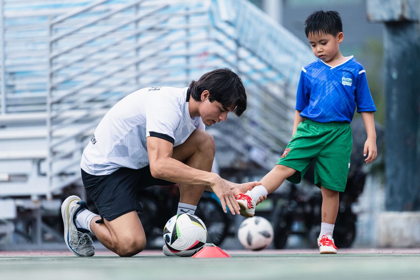 Coach kneeling to demonstrate a technique