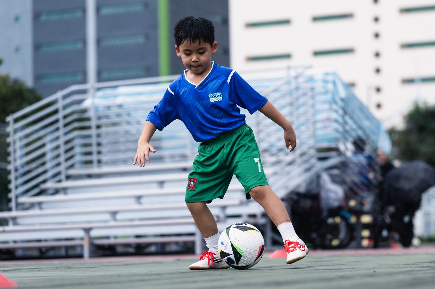 Primary student dribbling through cones